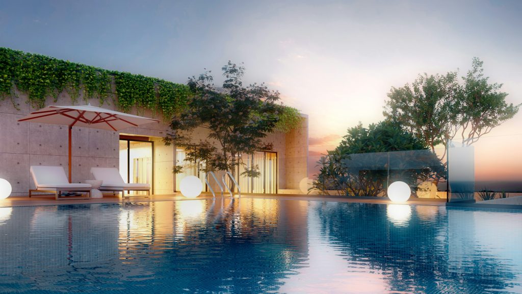 Deck de piscina com espreguiçadeiras e vegetação ao fundo na luz alaranjada do fim de tarde