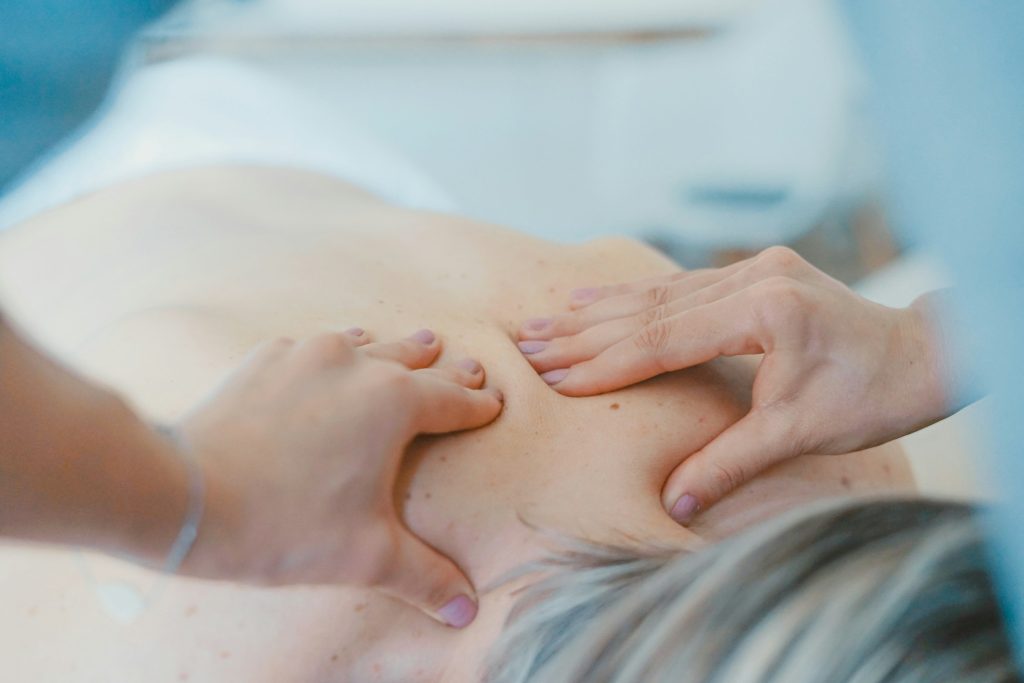 Sessao de massagem nas costas com toalha clara em ambiente tranquilo de spa